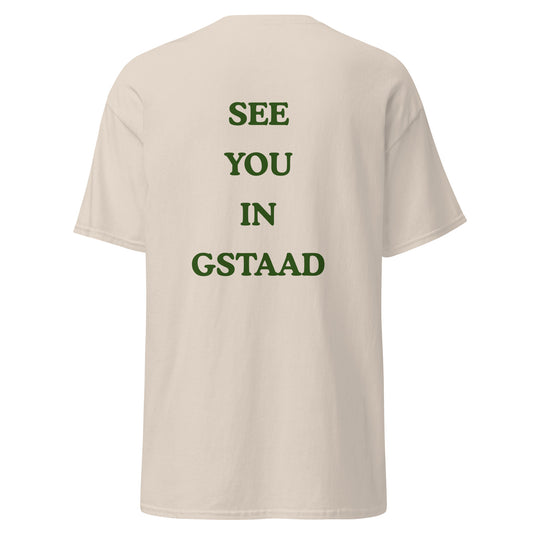 Green graphic text reading See You in Gstaad on the back of a natural colored unisex t-shirt
