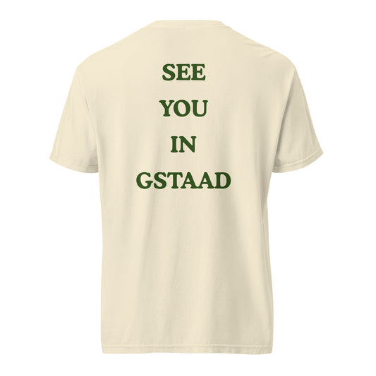 Green graphic text reading See You in Gstaad on the back of an ivory heavyweight t-shirt